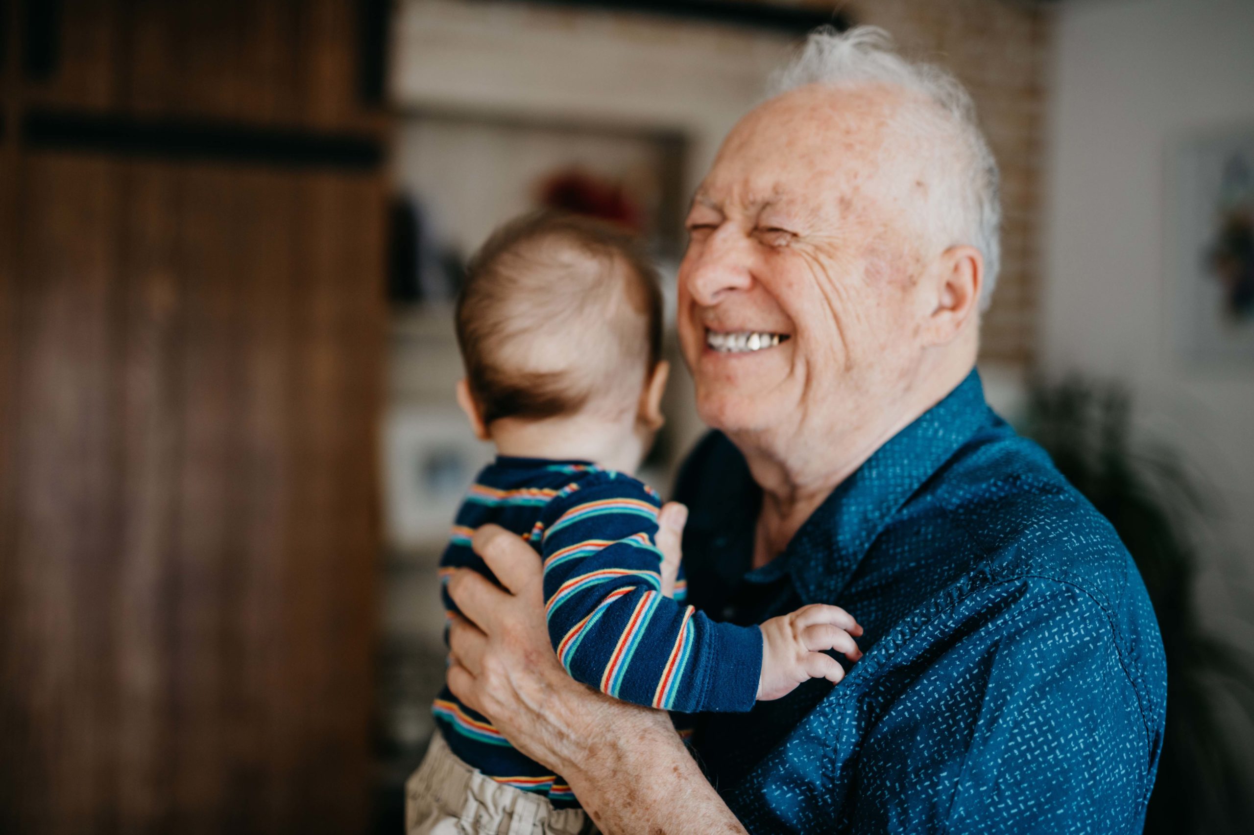 Great grandfather filled with joy embracing his great grandson