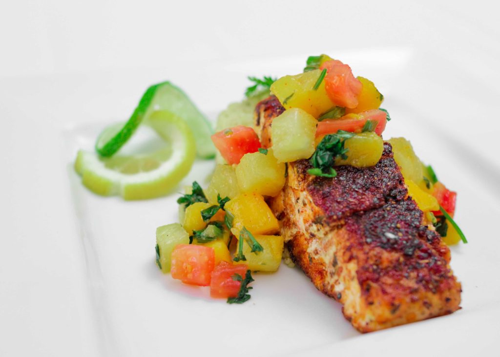 Salmon topped with diced fruit and vegetables