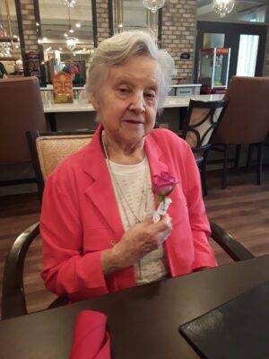 Senior female holding a pink flower