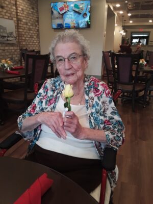 Senior female holding yellow flower